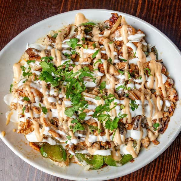 Happy Mexican's chicken fajita nachos, topped with sour cream, chipotle sauce, and fresh cilantro.