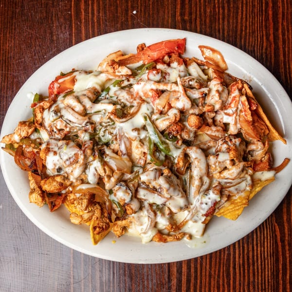 Happy Mexican's chicken fajita nachos, topped with melted white cheese, peppers, and onions.