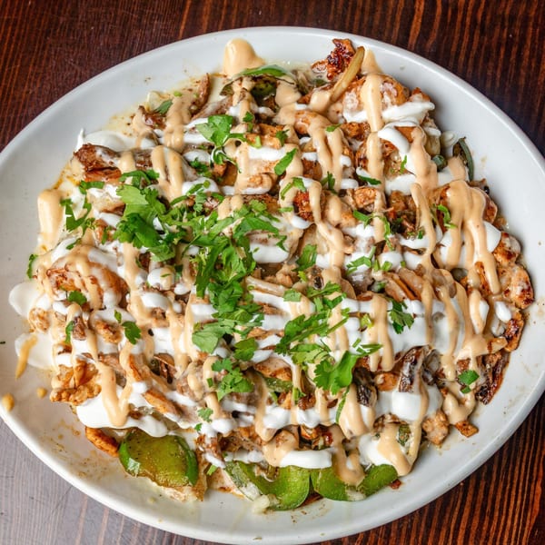 Happy Mexican's chicken fajita nachos, topped with sour cream, chipotle sauce, and cilantro.